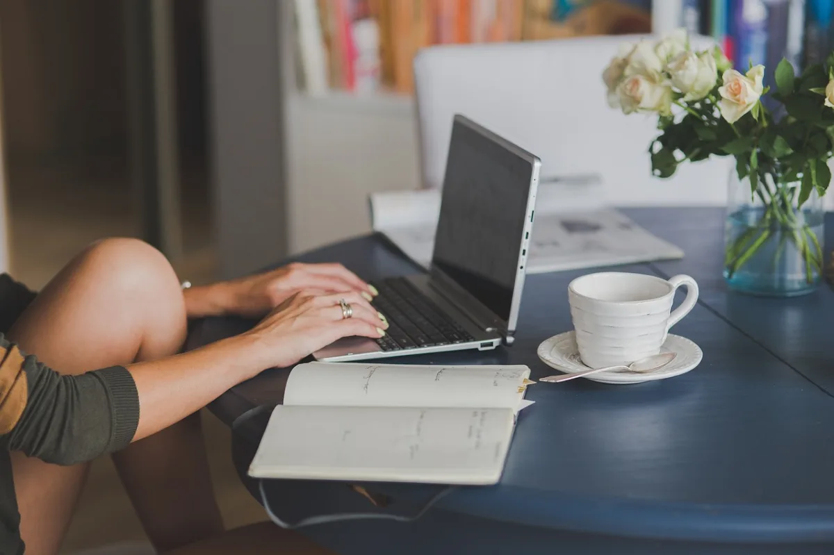 Laptop dan catatan perencanaan nama domain untuk blog di meja kerja