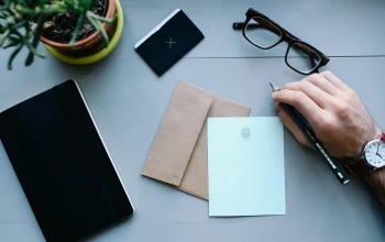 Laptop dan ponsel di meja kerja menampilkan tata letak blog yang sederhana