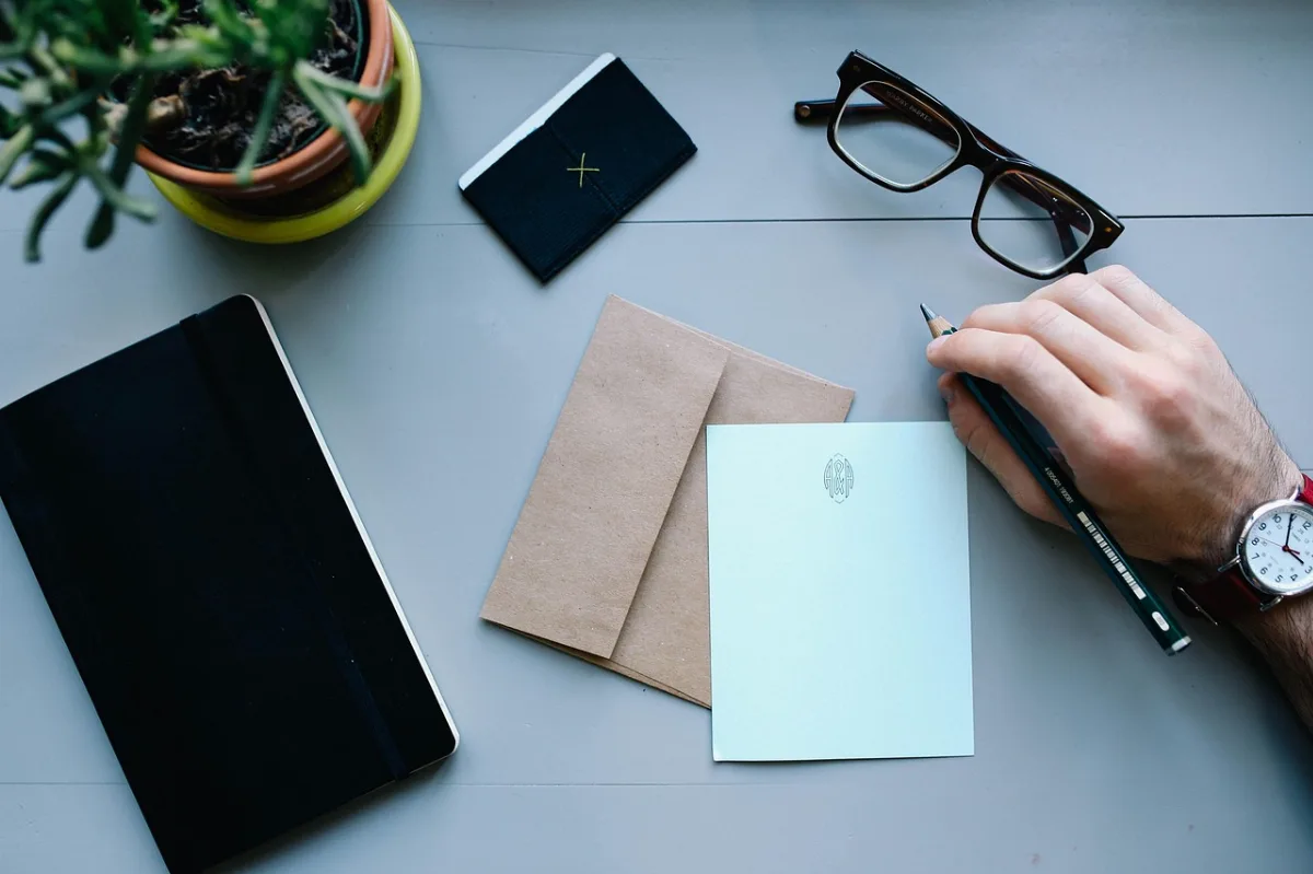 Laptop dan ponsel di meja kerja menampilkan tata letak blog yang sederhana